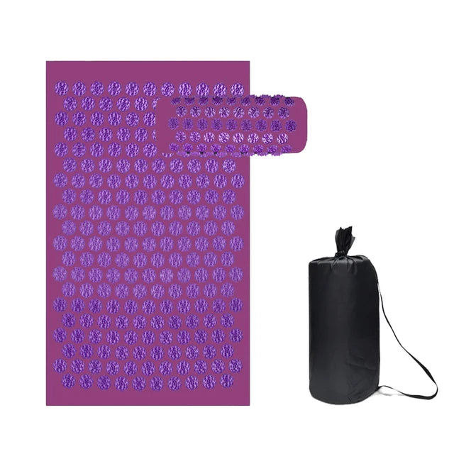 Purple acupressure mat and pillow set with plastic spikes for muscle relief, shown with a black carrying bag.