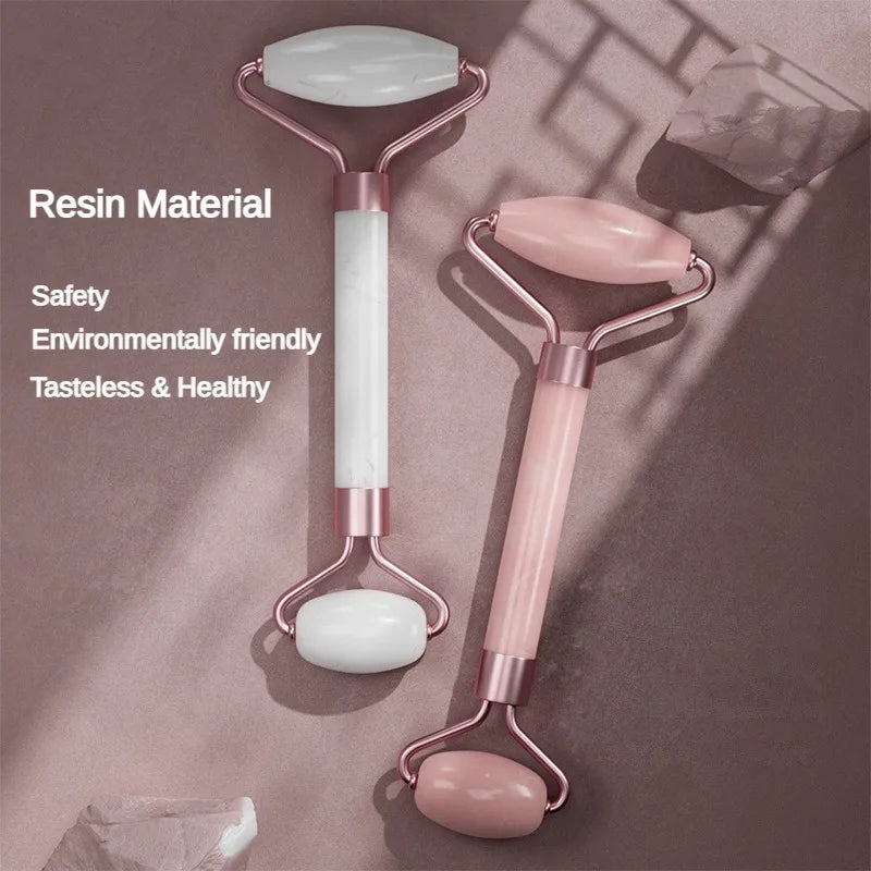 Two resin face massager rollers with rose gold frames, one white and one pink, set against a mauve background.
