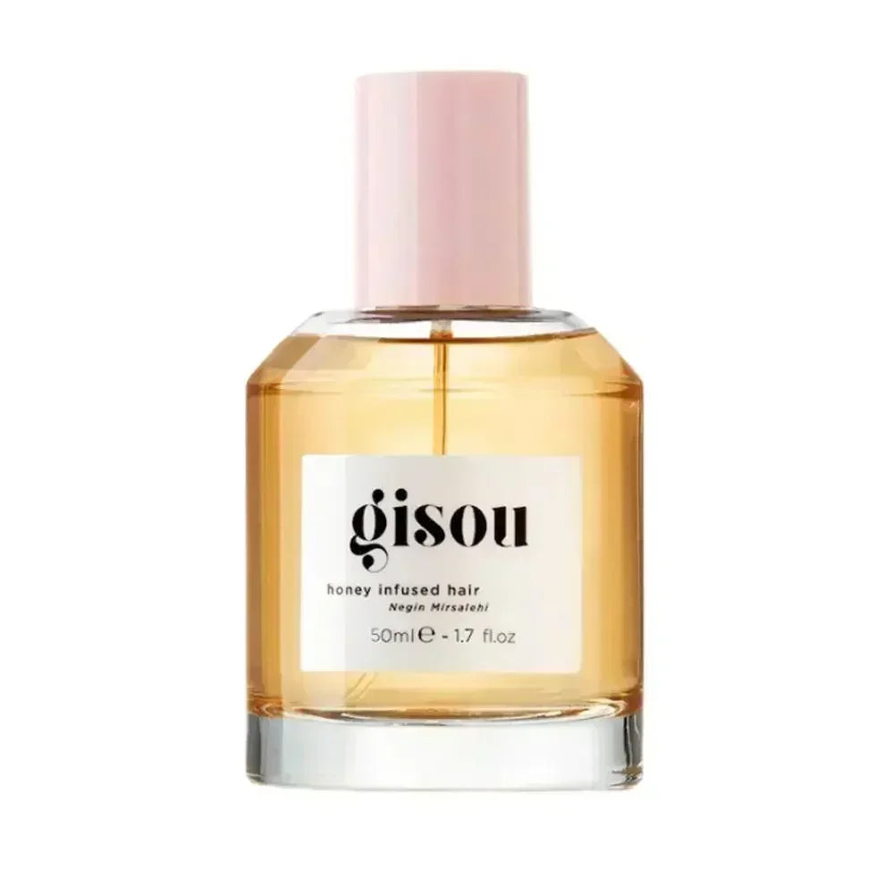 Gisou Honey Infused Hair Oil in a clear glass bottle with a light pink cap and golden amber liquid formula.