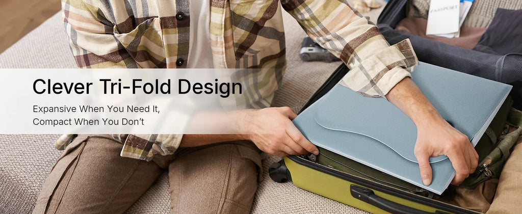 A person packs a folded, light blue Hello Face red light therapy mat into a carry-on suitcase.