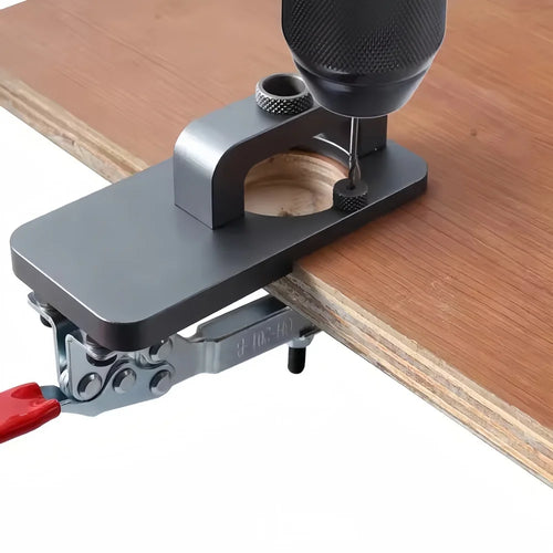 Gray hinge jig guide clamped on wood, with drill bit aligned through the guide hole