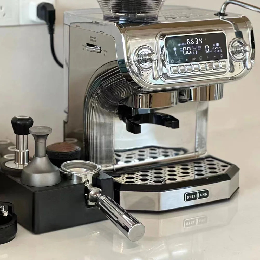 Stelang chrome espresso machine with digital display, portafilter, and metal tamper on a black stand.