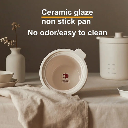White rice cooker with open ceramic inner lid showing nonstick pot bottom