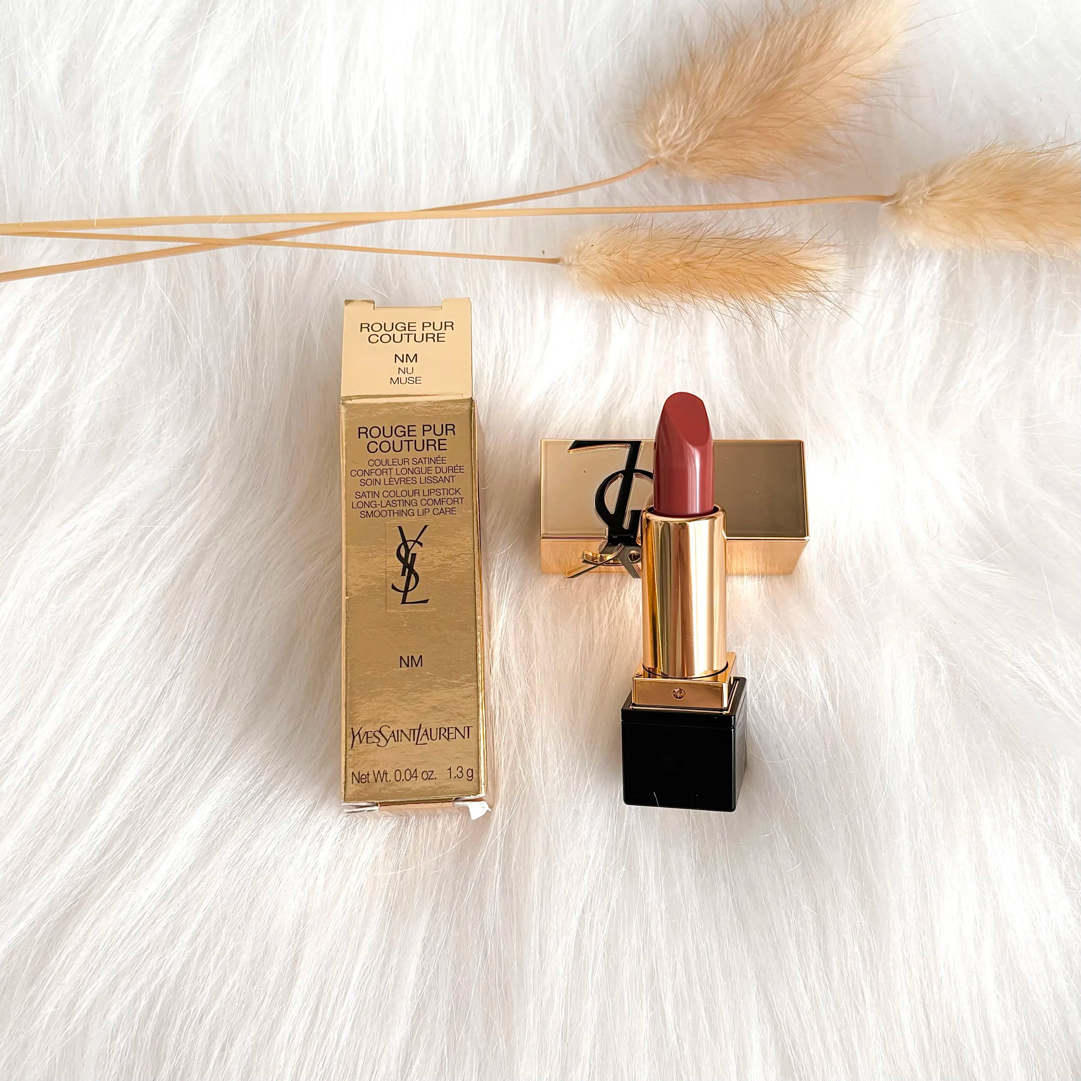 YSL Rouge Pur Couture mini lipstick in Nu Muse: satin finish, mauve-nude shade, gold packaging on a white fur background.