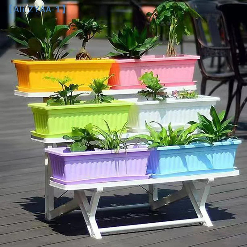 Multi-color rectangular plastic vegetable planters on a white stand with seedlings