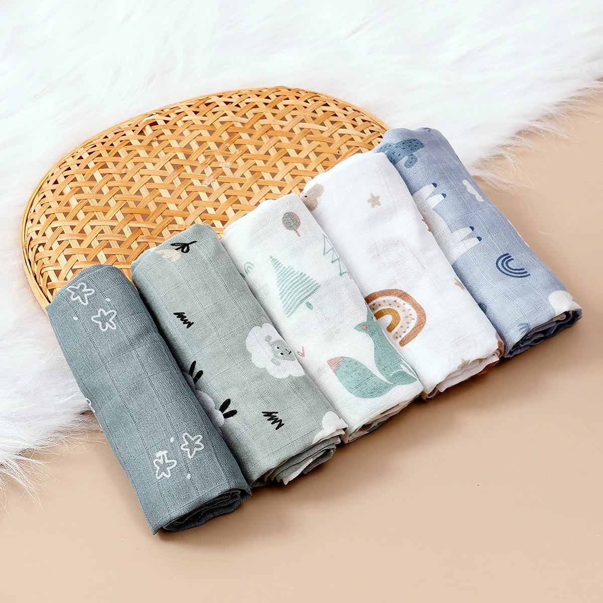 Set of 5 muslin baby swaddle blankets with cute woodland, rainbow, and sheep prints on soft cotton fabric.