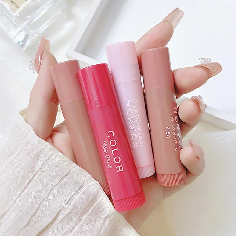 Set of four moisturizing tinted lip balms in pink and nude shades for hydrating, anti-dry lip care makeup.