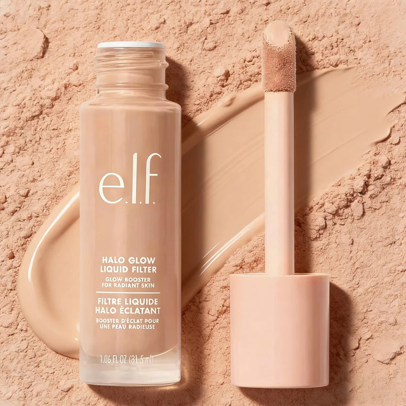 e.l.f. Halo Glow Liquid Filter foundation bottle and applicator with smooth, radiant beige texture on powder background.