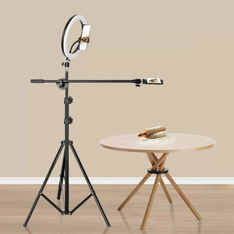 Black tripod stand with adjustable overhead arm, ring light, and phone mounts for recording top-down tabletop videos.