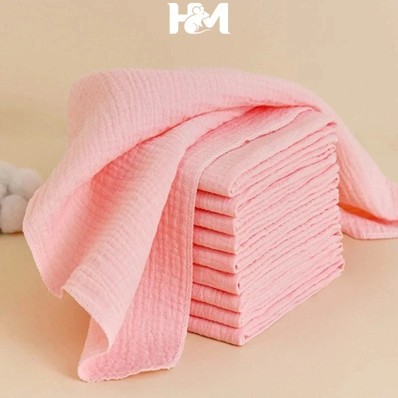 H&M baby care: stack of soft pink cotton muslin washcloths for gentle baby skincare.