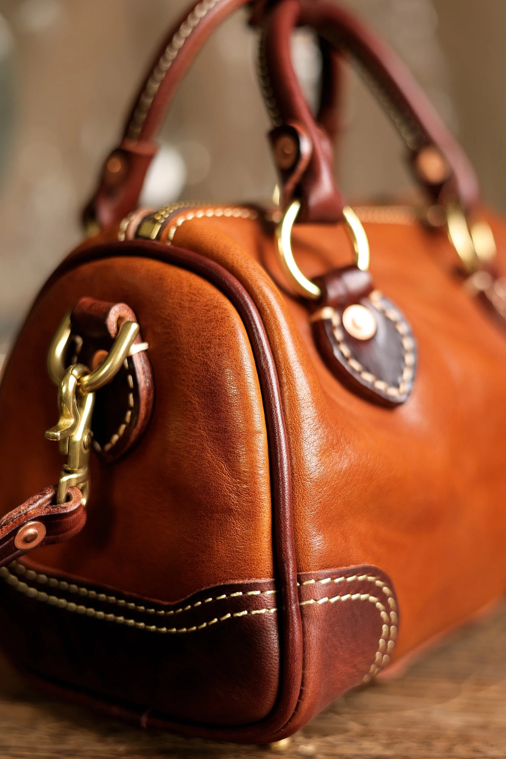 Vintage brown genuine cowhide leather handbag with brass hardware, contrast stitching, and structured top-handle design.