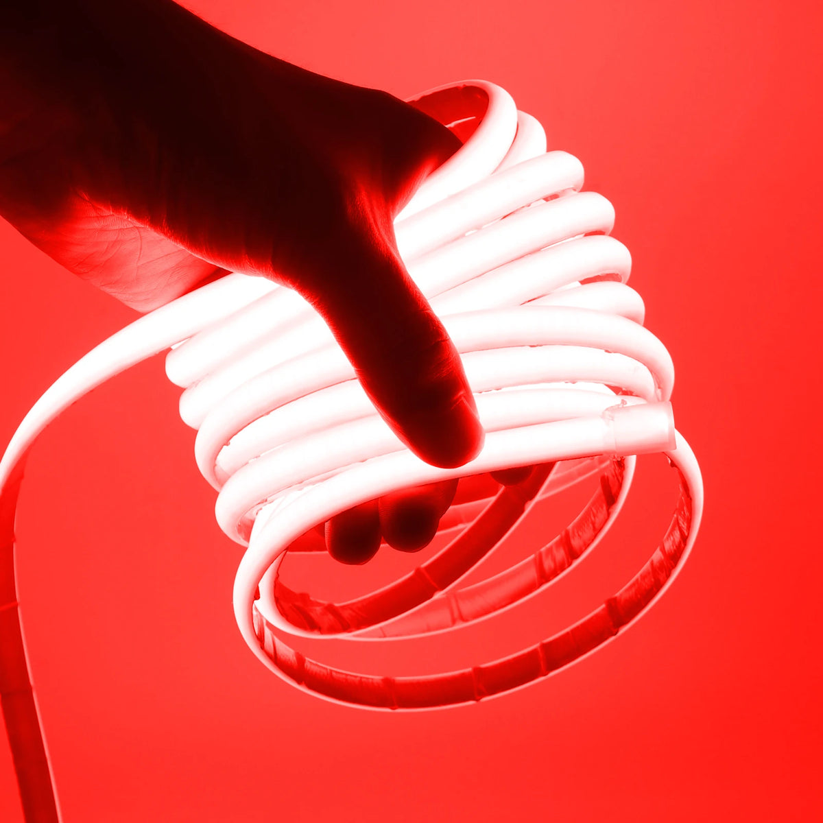 Waterproof COB LED neon strip light glowing red, held in hand