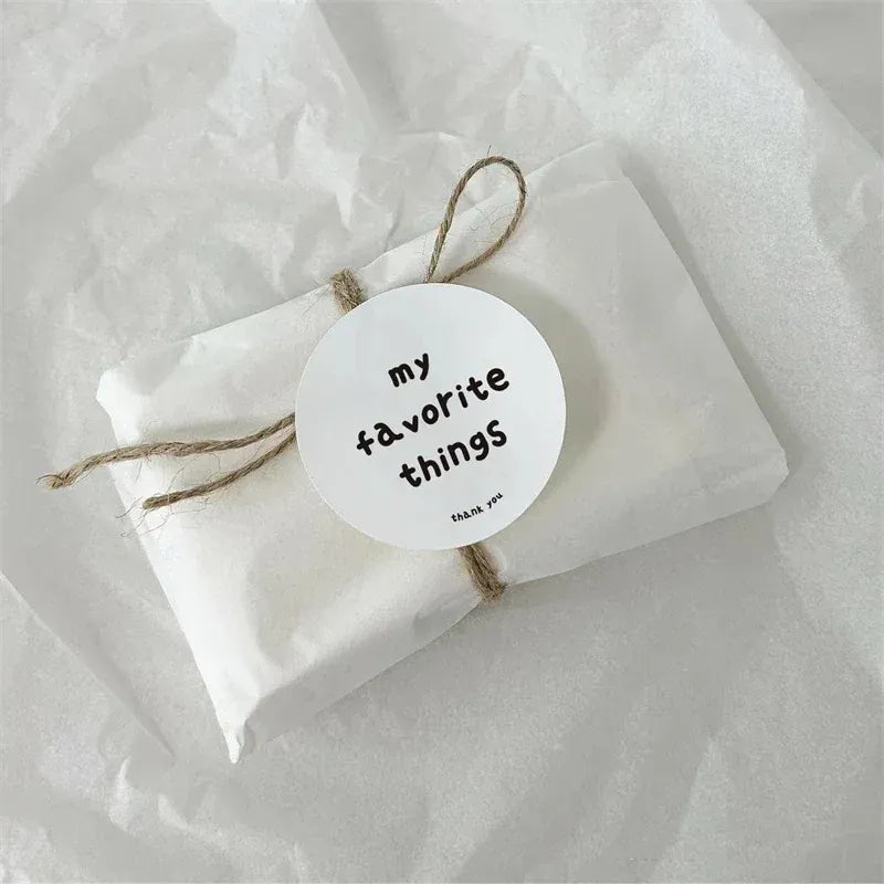 Round white “my favorite things” custom stickers with twine tied to a gift