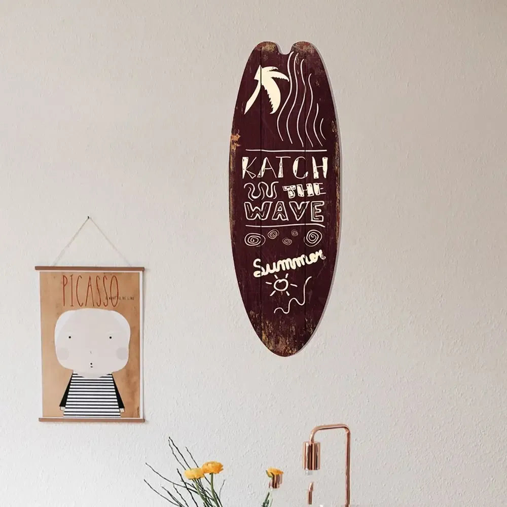 Wood surfboard hanging sign with dark maroon finish and “KATCH the WAVe” beach text