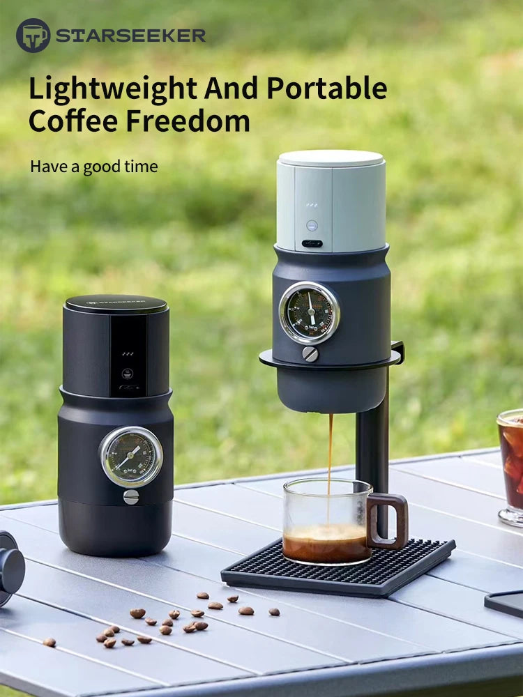 Starseeker portable espresso maker in black and grey with built-in pressure gauge, used outdoors on a camping table.