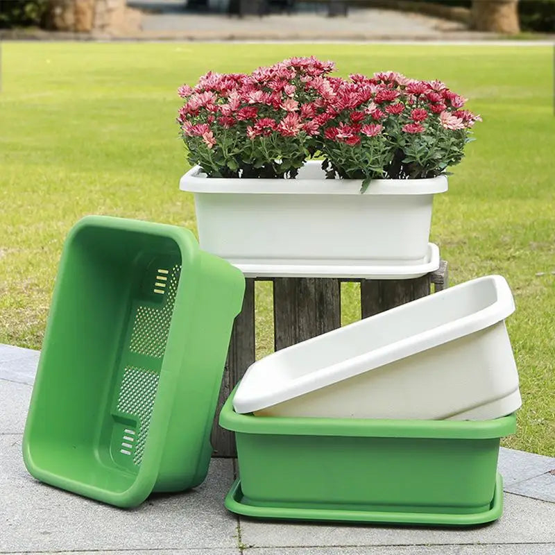 Green and white rectangular planter pots with matching trays, set on patio surface
