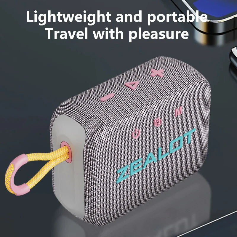 Light gray portable wireless speaker with pink icons, fabric mesh and ZEALOT logo