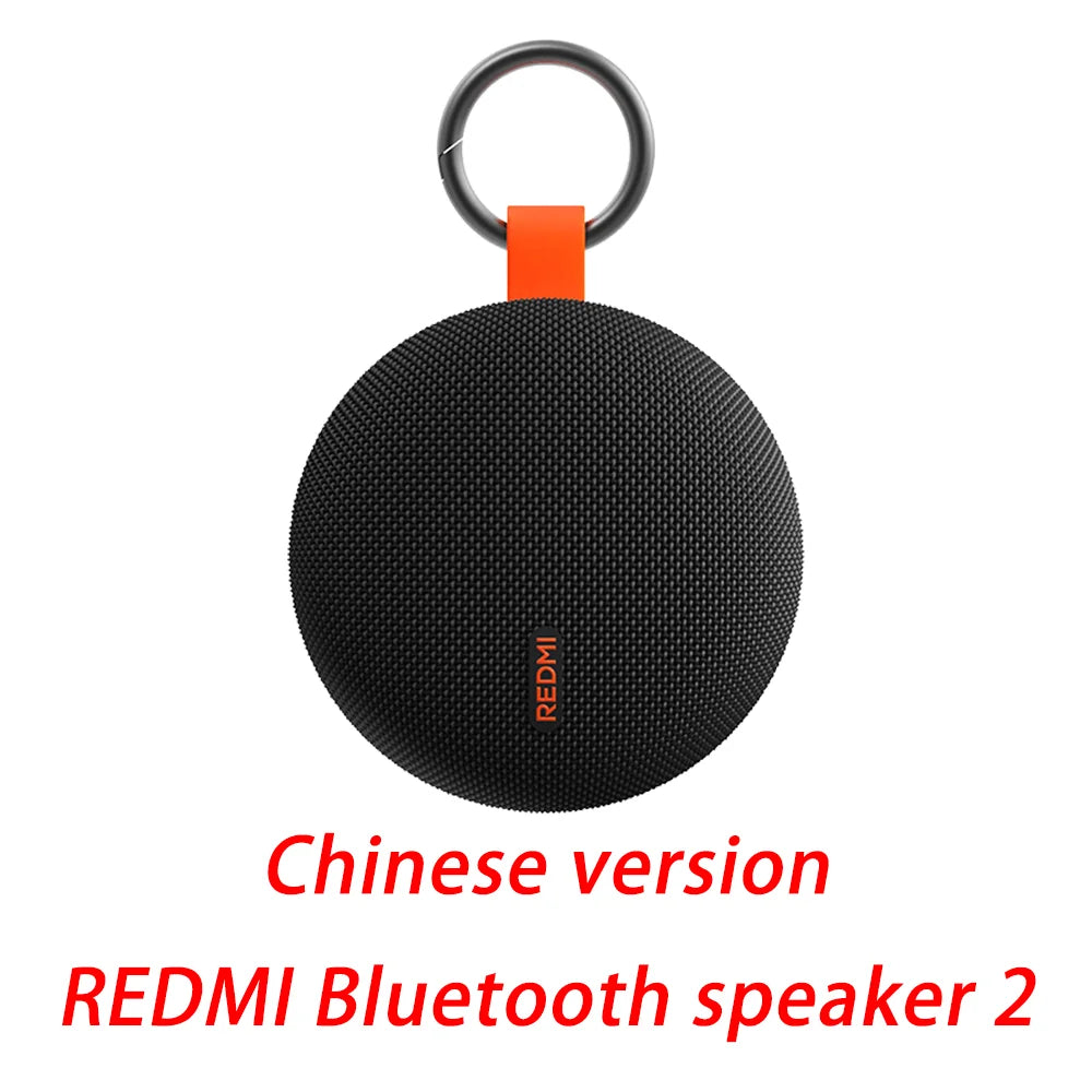 Round Bluetooth speaker with keyring and orange strap, black mesh body