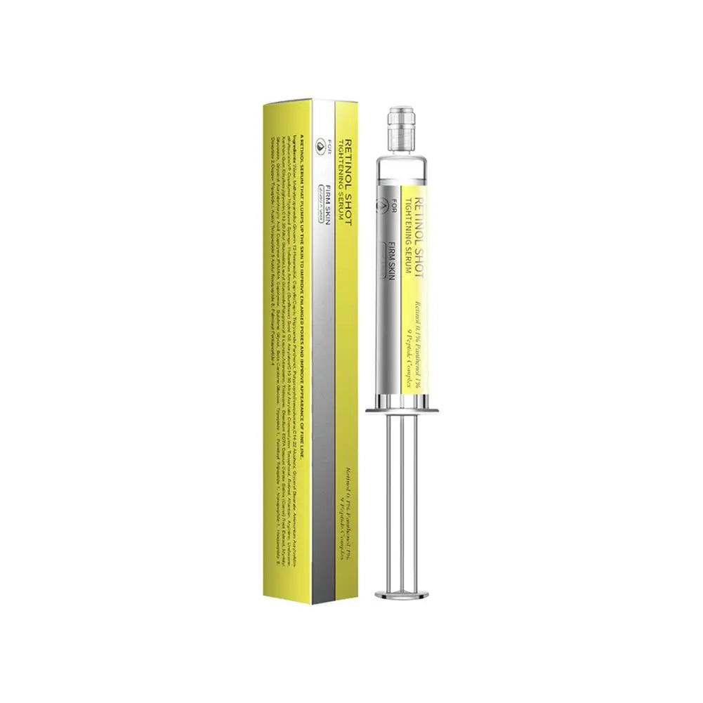 Retinol Shot tightening serum in a yellow and silver syringe applicator next to its matching cardboard box packaging.