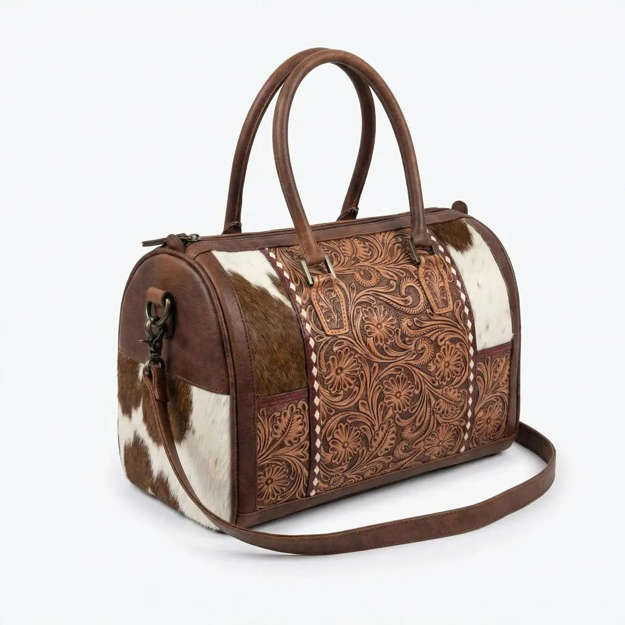 Genuine leather mini duffel with floral tooling and brown/white cowhide panels, zipper closure, and shoulder strap.