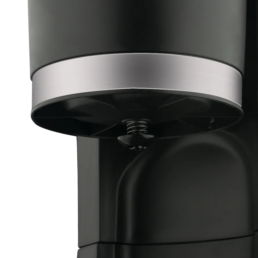 Black and silver coffee maker reservoir base detail with spring valve mechanism for automatic drip brewing.