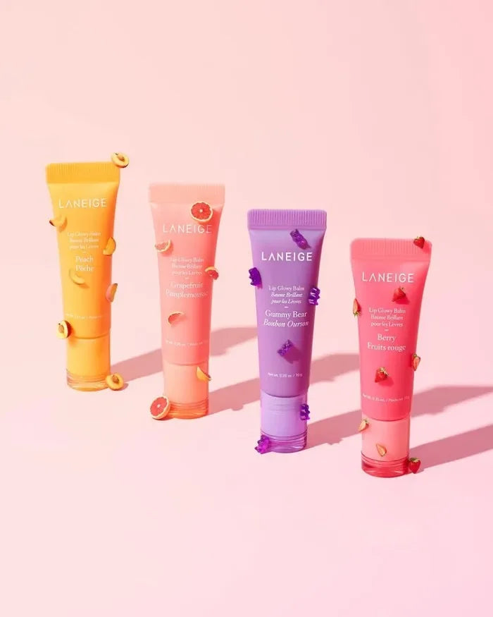 Four colorful Laneige Lip Glowy Balm tubes in peach, grapefruit, gummy bear, and berry for shiny, hydrated lips.