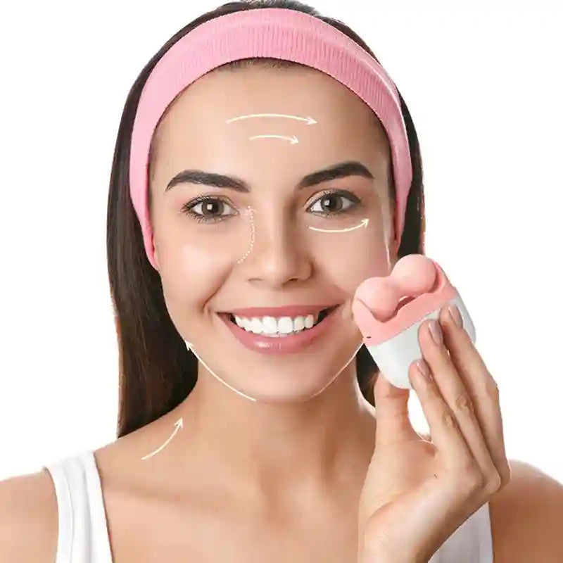 A woman wearing a pink headband uses a compact, white and pink dual-ball facial ice roller on her cheek.