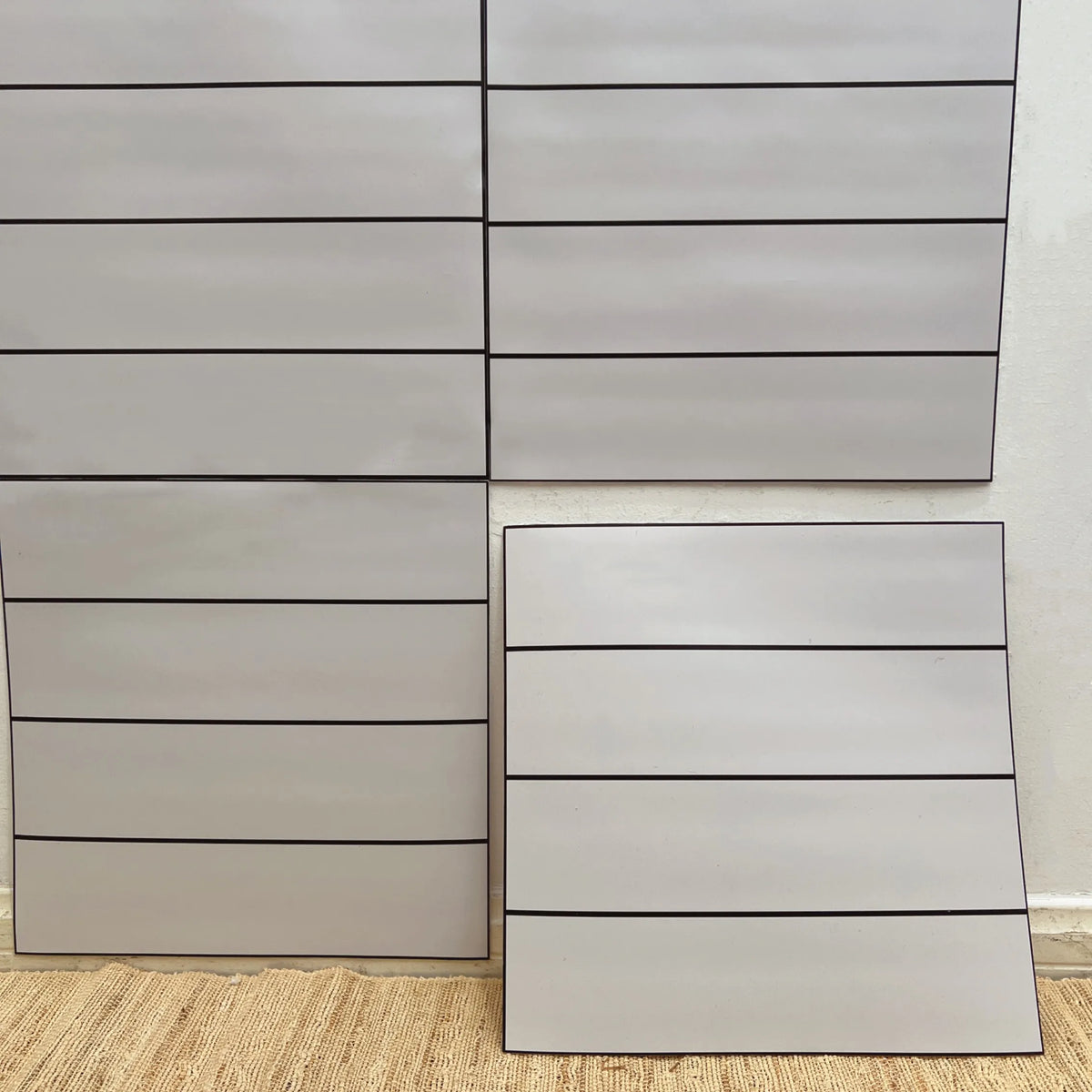 Light gray marble-effect peel-and-stick backsplash tile sheet with grid grout lines