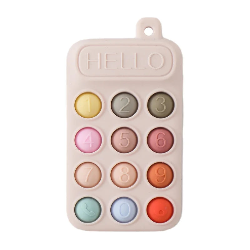 Beige silicone baby teething toy in phone shape with colorful number buttons for gum relief.