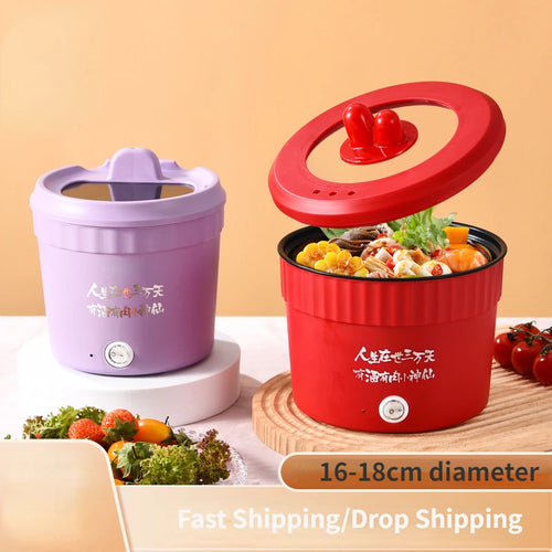 Red electric mini hot pot with lid, holding noodles and vegetables inside