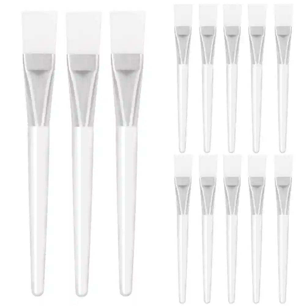 A collection of facial mask brushes with white silicone heads, silver metal ferrules, and translucent white handles.