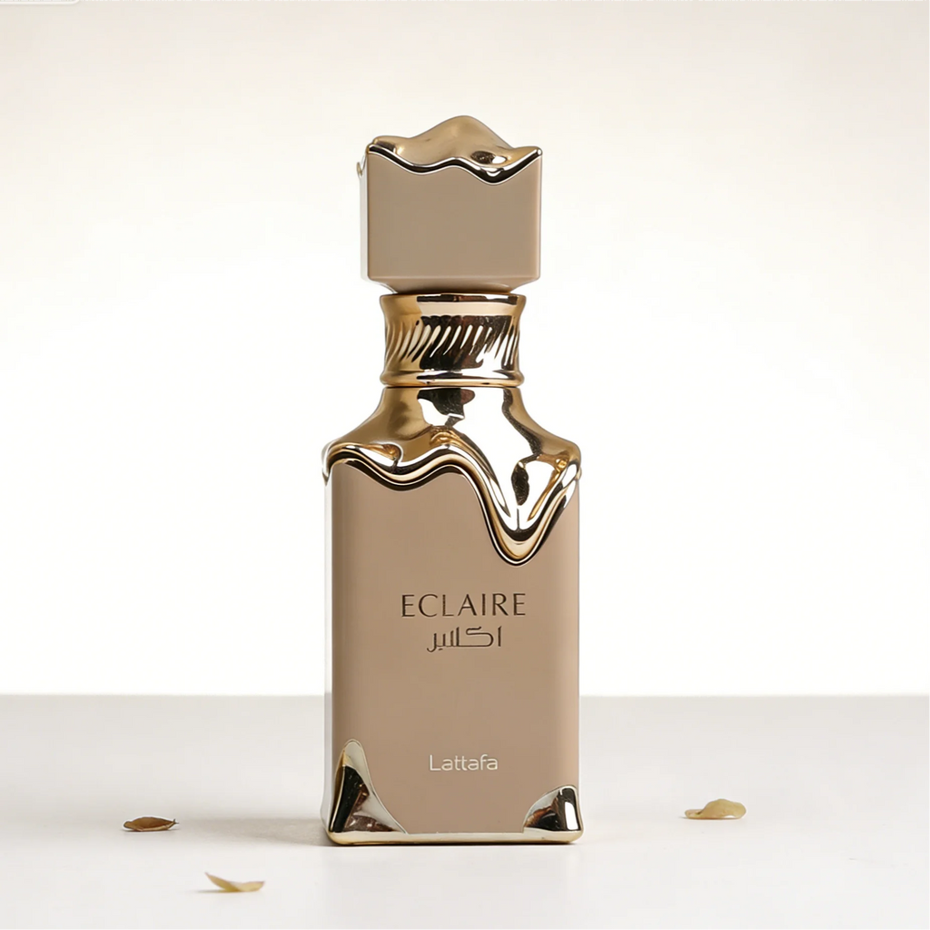 Lattafa Eclaire perfume bottle in beige with gold drip design and a sleek, modern luxury aesthetic on white surface.