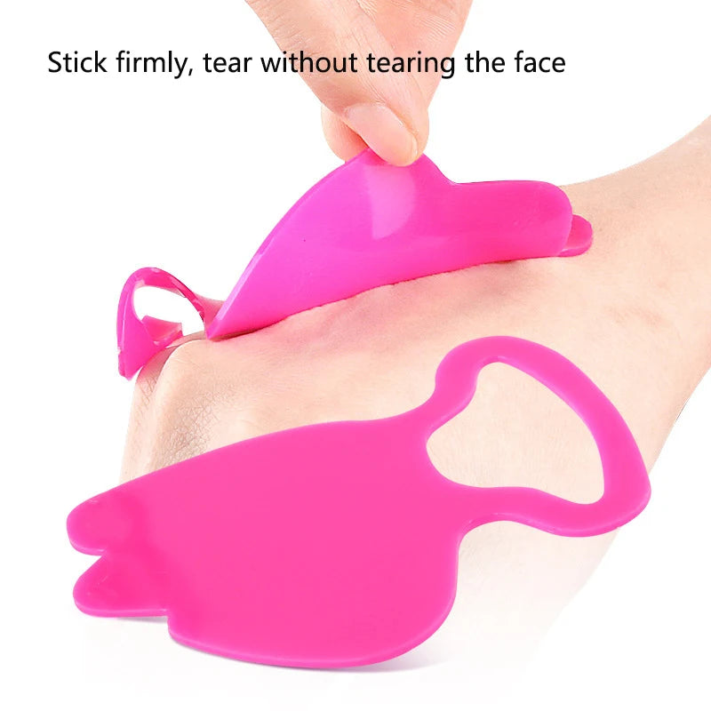 Fingers applying a reusable, bright pink silicone anti-wrinkle patch to the skin.