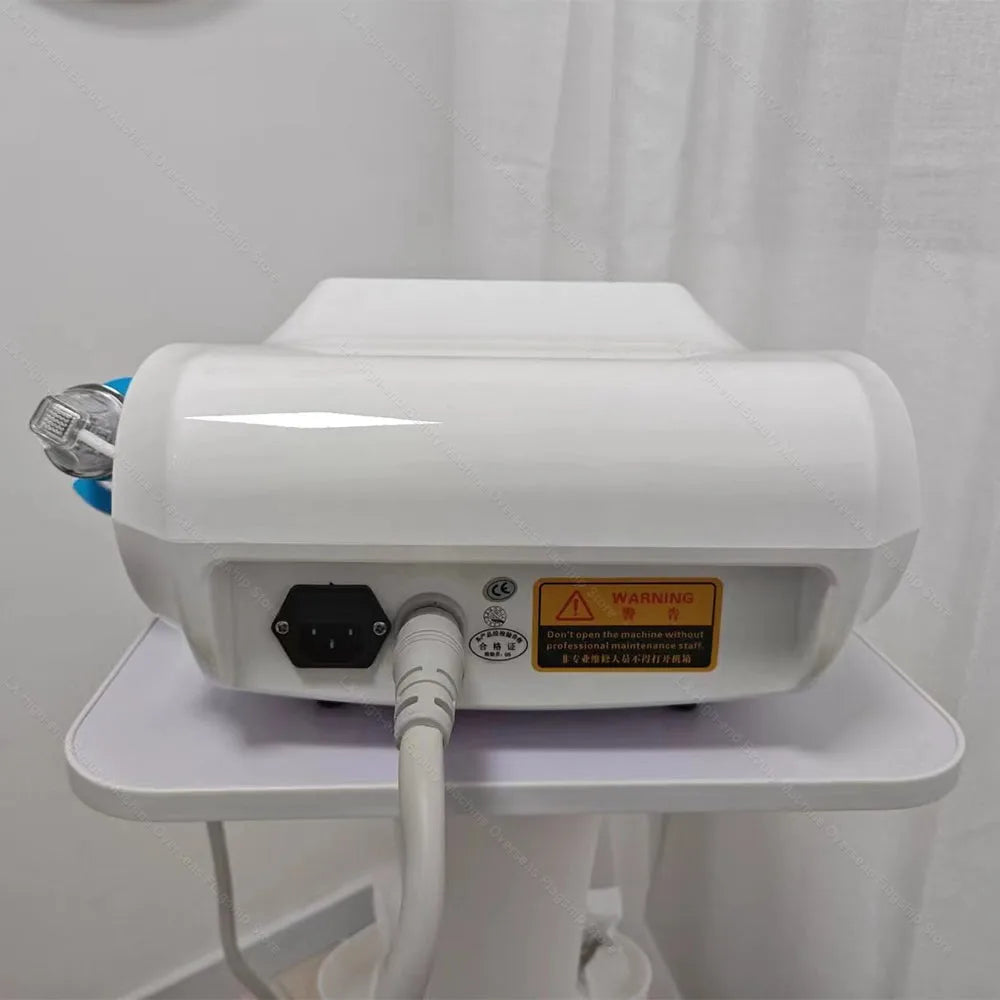 White portable RF microneedle skin tightening machine rear view with power cord, warning label, and treatment handpiece.
