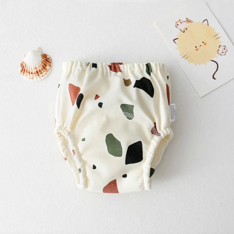 Baby training diaper with cream-colored abstract terrazzo print for toddlers. Comfortable, reusable baby care essential.