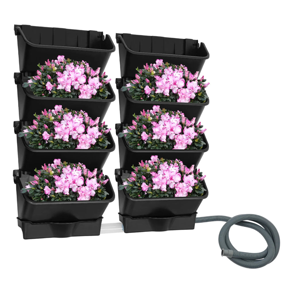 Black vertical wall planter with six planters filled with pink flowers and gray hose