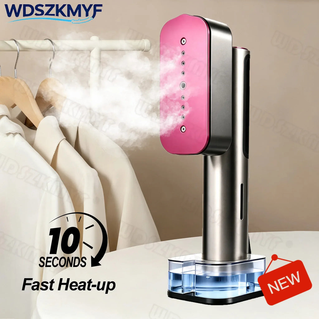 Handheld garment steamer in pink and silver releasing steam toward clothes hanging on a rack.