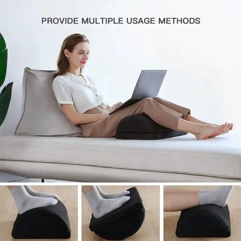 Adjustable black memory foam foot rest for office desk or couch use to provide back, hip, and leg pain relief.
