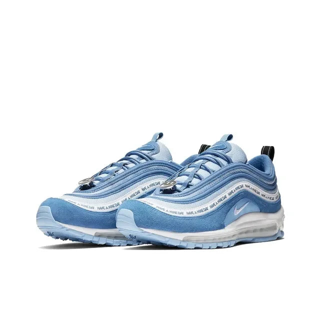 Blue Nike Air Max 97 Have A Nike Day sneakers with suede overlays, smiley face lace dubraes, and white cushioning.