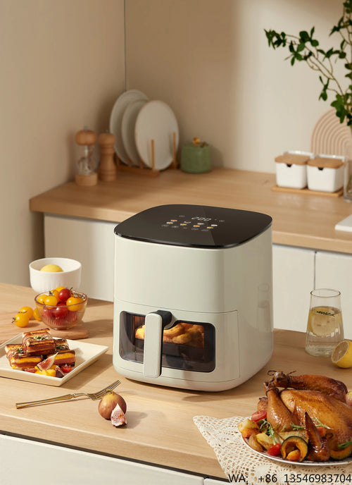 White air fryer on kitchen counter with transparent window and handle