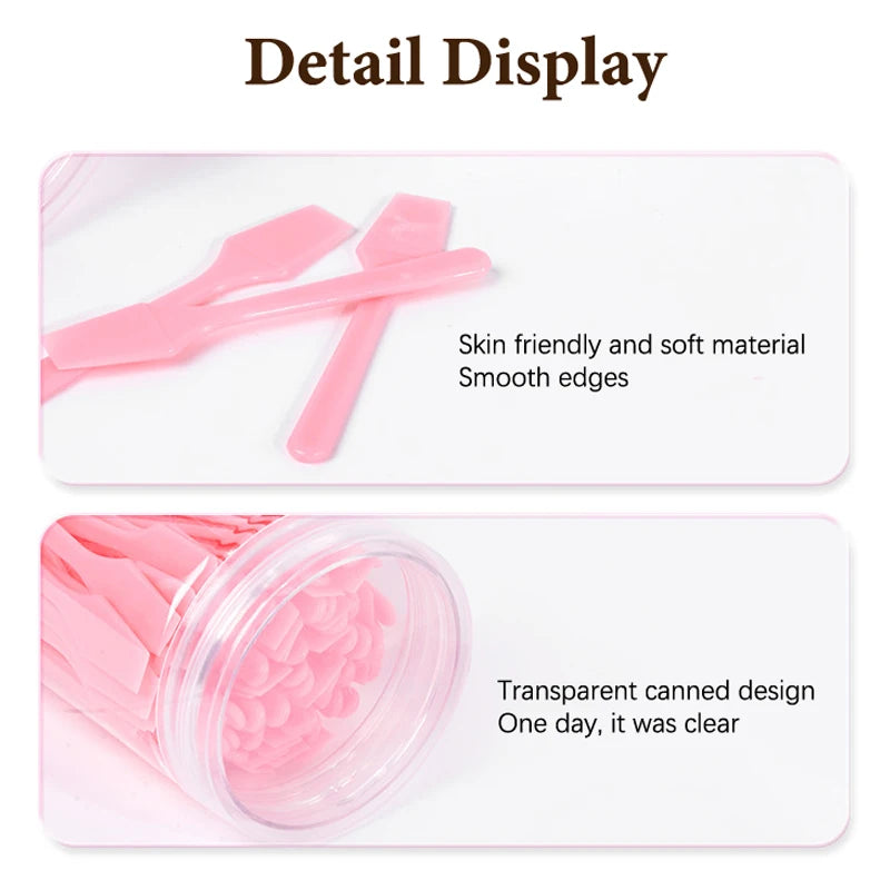 A set of small, pink plastic cosmetic spatulas with smooth edges, stored in a clear cylindrical container.