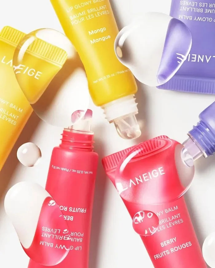 Laneige Lip Glowy Balm set in colorful tubes: Mango yellow, Berry pink, and purple, featuring glossy lip treatment texture.