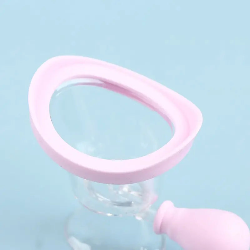 Reusable soft pink silicone eye wash cup for gentle eye cleansing and flushing on a light blue background.