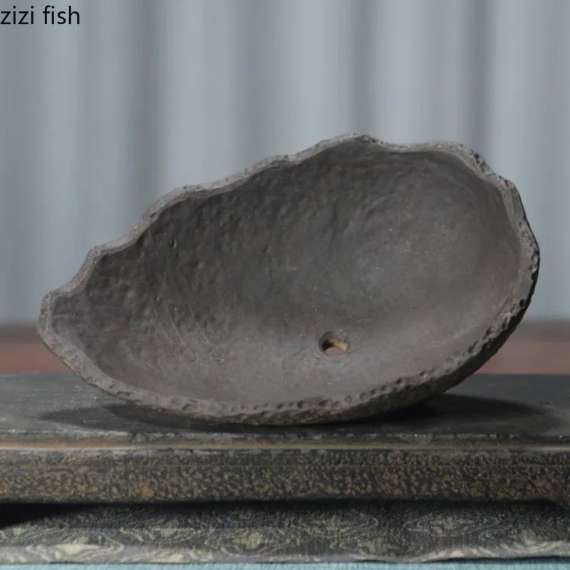 Ceramic planter base in bowl shape with one small drainage hole and dark interior