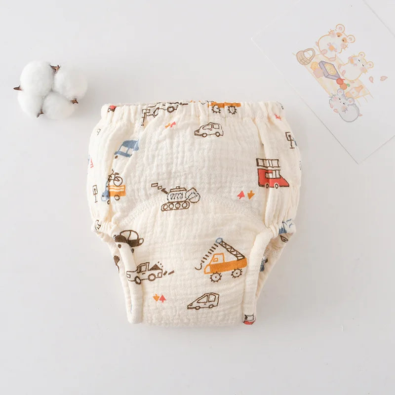 Baby cloth training diaper in cream with colorful construction vehicle print for potty training.