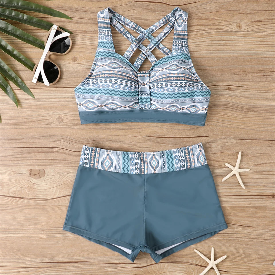 Tidesmit blue high-waist bikini set with tribal print, crisscross straps, padded top, and smooth material on wood surface.