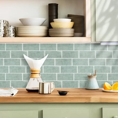 Green brick-pattern 3D backsplash tiles on kitchen wall with countertop edge