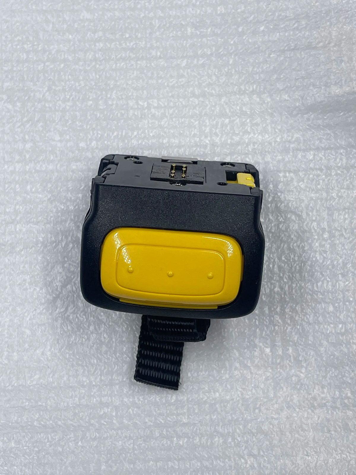 Black scanner trigger module with yellow button, viewed from front