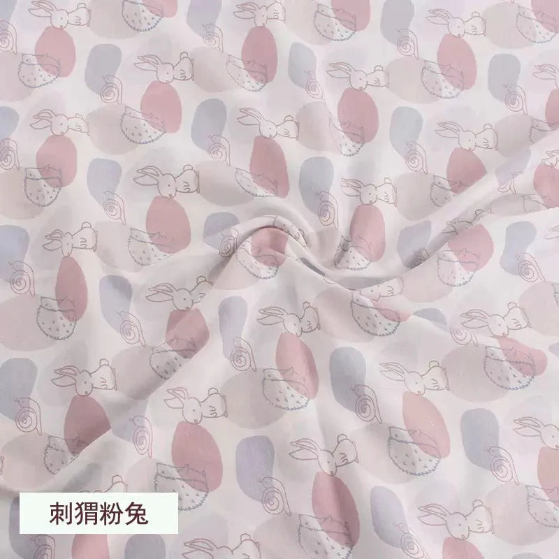 Tidesmit jersey fabric with pink and blue abstract shapes, bunnies, and hedgehogs, ideal for soft children's clothing.