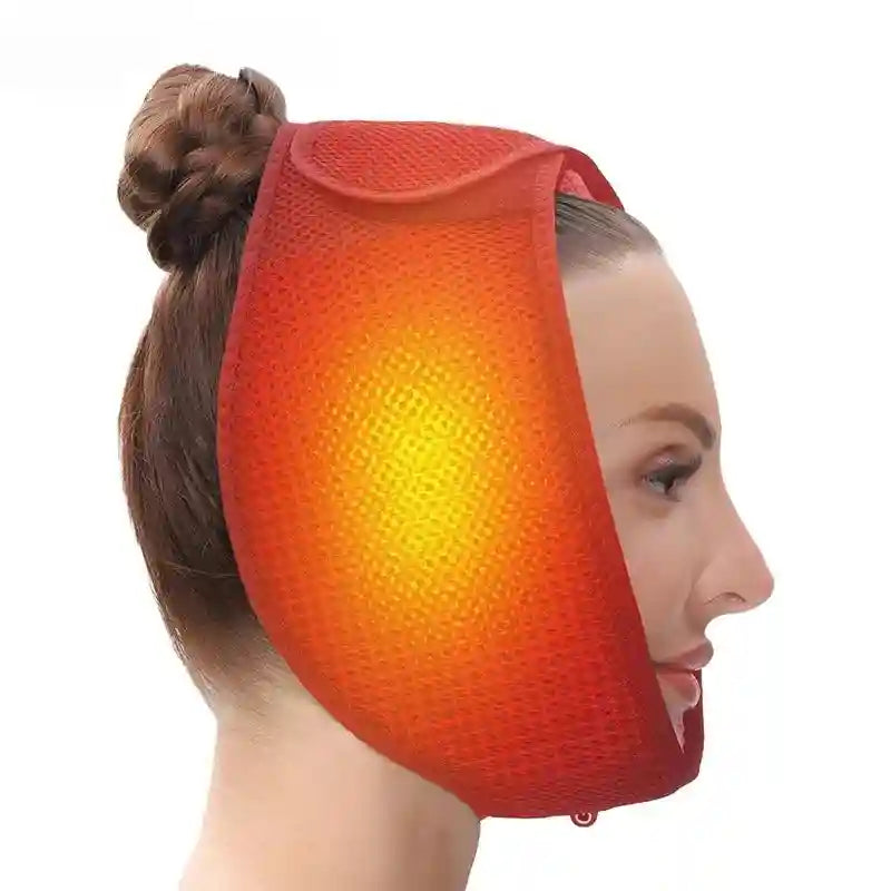 A woman wearing a red, mesh, adjustable heated jaw wrap with a glowing orange heat zone on her cheek.
